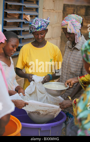 In Ouagadougou, Burkina Faso, Fulani Frauen zusammenarbeiten, um eine traditionelle Hirse-Getränk für ein Baby Taufe Party zu machen. Stockfoto