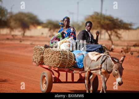 Eine Familie bringt geerntete Hirse auf den Markt von Eselskarren in Djibo, Burkina Faso. Stockfoto