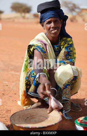 Eine Fulbe-Frau trägt Milch in einer Kalebasse zum Verkauf in der Wochenmarkt von Djibo im nördlichen Burkina Faso. Stockfoto