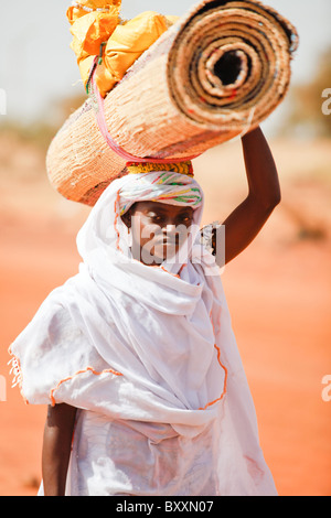 In Djibo im nördlichen Burkina Faso bringt ein Fulani Womea handgewebte Strohmatten auf den Markt zu verkaufen. Stockfoto