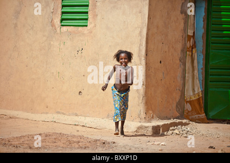 Eine Fulani Mädchen steht gegen ein Lehmhaus in der Stadt Djibo im nördlichen Burkina Faso. Stockfoto