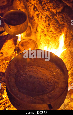 Eine Frau in Djibo, Burkina Faso kocht Hirse "Pot", ähnlich wie die italienische Polenta auf ein offenes Feuer im Freien. Stockfoto