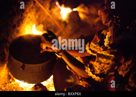 Eine Frau in Djibo, Burkina Faso kocht Hirse "Pot", ähnlich wie die italienische Polenta auf ein offenes Feuer im Freien. Stockfoto