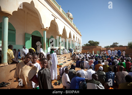 Am Morgen des Tabaski konvergieren Männer, Frauen und Kinder gleichermaßen auf die große Moschee von Djibo im nördlichen Burkina Faso. Stockfoto