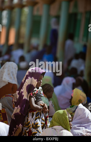 Am Morgen des Tabaski konvergieren Männer, Frauen und Kinder gleichermaßen auf die große Moschee von Djibo im nördlichen Burkina Faso. Stockfoto