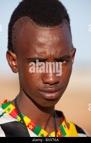 Ein junger Musiker der Fulbe aus einem Dorf im nördlichen Burkina Faso Sport einen im Modus Frisur. Stockfoto