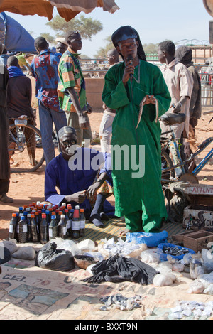 Auf dem Wochenmarkt in Djibo, nördlichen Burkina Faso, eine Menschenmenge versammelt um einen Schlangenbeschwörer / traditionellen Medizinmann. Stockfoto