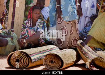 Eine Fulbe-Frau verkauft handgewebte Strohmatten auf dem Wochenmarkt in Djibo im nördlichen Burkina Faso. Stockfoto