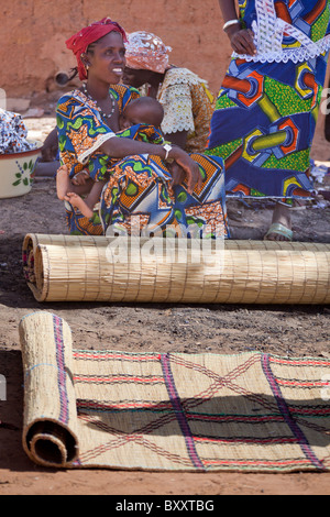 Eine Fulbe-Frau verkauft handgewebte Strohmatten auf dem Wochenmarkt in Djibo im nördlichen Burkina Faso. Stockfoto