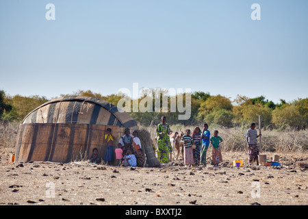 In saisonalen Dorf Bantagiri im Norden Burkina Faso Pfund Fulani Frauen Hirse außerhalb ein Haus aus Stroh Mat. Stockfoto