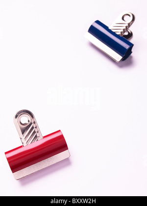 2 zwei rote Bulldog Clips auf einem weißen Hintergrund blau Stockfoto