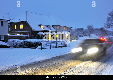 Fahren auf Schnee bedeckt Straßen in der Abenddämmerung Stockfoto