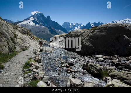 Ein Fluss führt von Lac Blanc, gegenüber die Gipfel der Aiguille Verte und Mont Blanc, französischen Alpen. Stockfoto