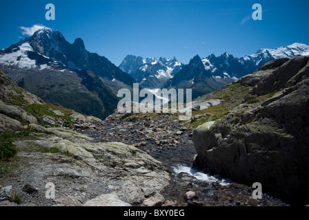 Ein Fluss führt von Lac Blanc, gegenüber die Gipfel der Aiguille Verte und Mont Blanc, französischen Alpen. Stockfoto