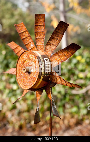 Eine handgefertigte Windmühle hergestellt aus einer alten Kaffee Dose hilft Schrecken Vögel weg von diesem kleinen Garten. Stockfoto