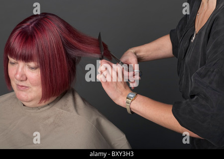 Studioaufnahme von Friseur schneiden das Haar der Frau Stockfoto