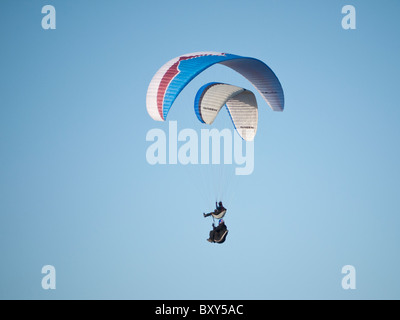 Team 5 grün und Ozon Delta Gleitschirme fliegen zusammen in einem klaren blauen Himmel am Milk Hill nördlich von Alton Barnes, Marlborough Stockfoto