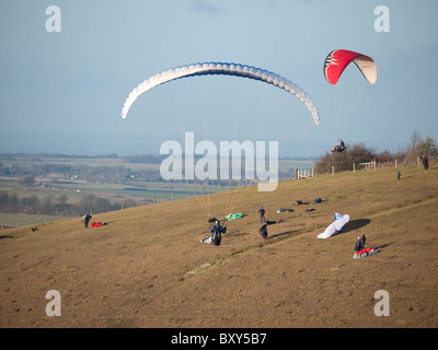 Paragliding-Enthusiasten am Milk Hill nördlich von Alton Barnes in der Nähe von Marlborough, Wiltshire genießen Sie eine perfekte Tage fliegen Stockfoto