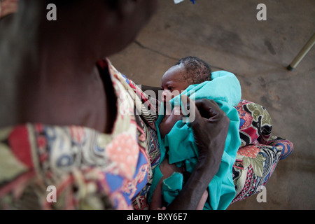 Eine Mutter hält ein neugeborenes Baby in der Entbindungsstation am Amuria Gesundheit Zentrum IV - Amuria District, Uganda, Ostafrika. Stockfoto