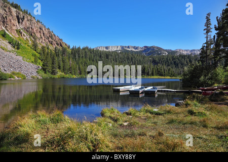 Kleine Boote auf der Anklagebank in einem ruhigen und malerischen Bergsee Stockfoto