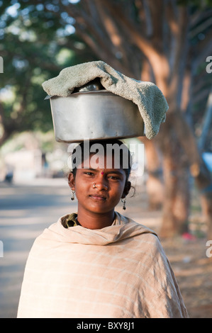 Armen niedrigere Kaste indischen Teenager-Mädchen tragen einen Topf mit Reis auf den Kopf. Andhra Pradesh, Indien Stockfoto