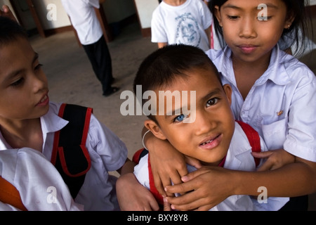 Ein Tauber asiatischen 9-jähriger Junge mit anderen farbigen Augen wird von einem Freund in einem Krankenhaus in kommunistische Laos gehalten. Stockfoto