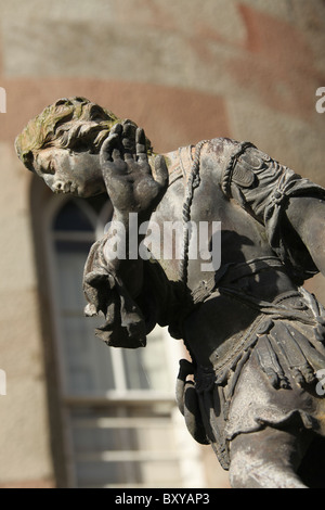 Cholmondeley Schlossgärten. Nahaufnahme einer Statue mit Cholmondeley Schloß im Hintergrund. Stockfoto