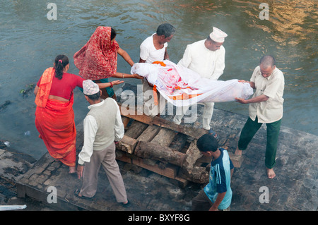 letzte Riten bei einer Einäscherung Beerdigung am Fluss Bagmati im Pahsupatinath Tempel in Kathmandu, Nepal Stockfoto