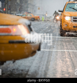 Nahaufnahme des gelben Taxi auf der Straße im Schnee Stockfoto