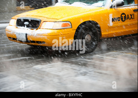 Nahaufnahme des gelben Taxi auf der Straße im Schnee Stockfoto