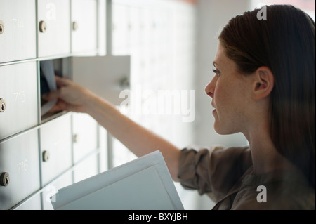 Frau nehmen Briefe aus Postfach Stockfoto