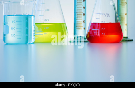 Becher und Flaschen mit bunten Flüssigkeiten Stockfoto