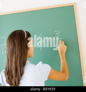 Schreiben an die Tafel in der Klasse Mädchen Stockfoto