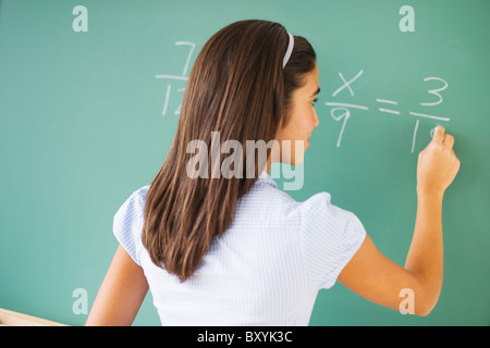 Schreiben an die Tafel in der Klasse Mädchen Stockfoto