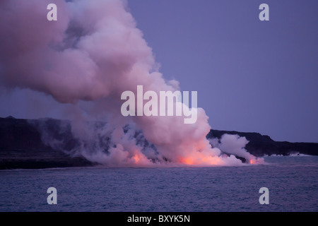 Einen ausbrechenden Vulkan in Hawaiʻi-Volcanoes-Nationalpark in der Abenddämmerung. Stockfoto