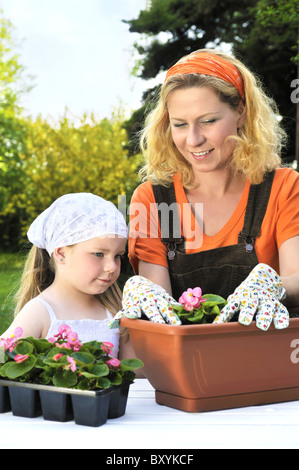 Junge Frau und ihr Kind Blumen Blumenerde Stockfoto