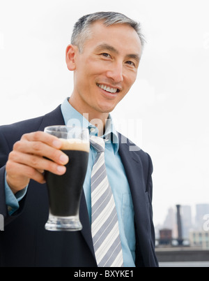 Geschäftsmann halten Pint Bier und Blick in die Kamera Stockfoto
