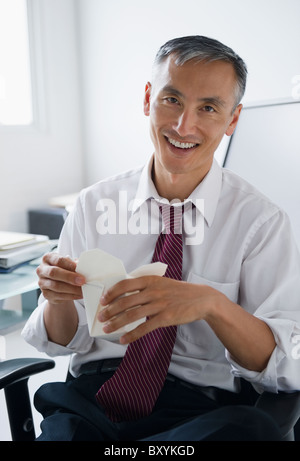 Porträt von lächelnden Geschäftsmann hält Chinesisch zum mitnehmen Stockfoto