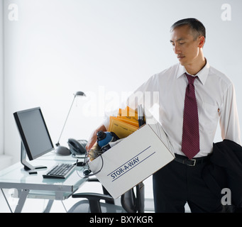 Unternehmer mit seinen persönlichen Habseligkeiten in box Stockfoto