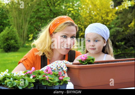 Junge Frau und ihr Kind Blumen Blumenerde Stockfoto