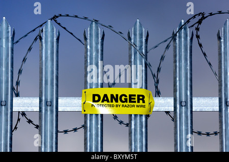 Warnschild Warnung vor Ziehharmonika-Rasiermesserdraht auf verzinktem Stahl montiert wies Zaun. Stockfoto