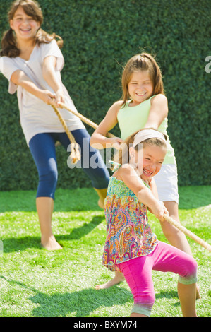 Schwestern spielen Tauziehen Stockfoto