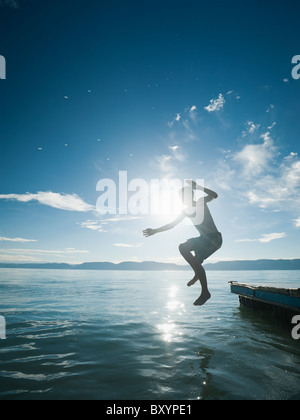 Junge aus Floß springen Stockfoto