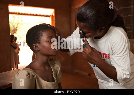 Medizinisches Personal prüfen die Augen der Studenten in einer afrikanischen Dorfschule im Rahmen eines Projekts NGO gegen Flussblindheit. Stockfoto
