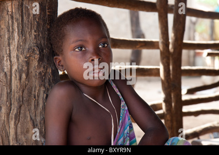 Ein Kind, dessen Dorf in ein Community-Empowerment-Projekt von einer NGO teilgenommen, sitzt in den Ziegenstall. Stockfoto