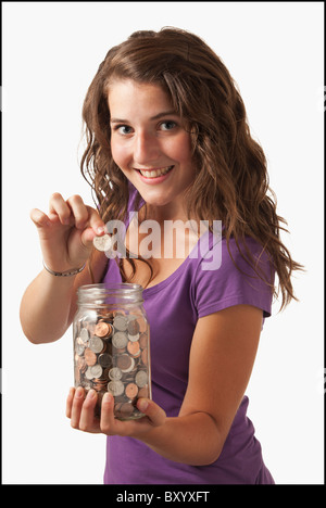 Junge Frau mit Glas mit Münzen Stockfoto
