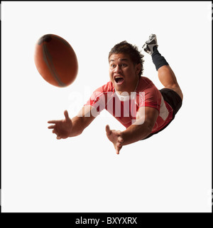 Männlichen Rugby-Spieler Tauchen für ball Stockfoto