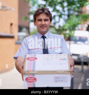 Royal Mail Postbote mit einem Paket in England in Großbritannien in die Vereinigten Kingdom.Occupation Arbeit Post Lieferservice Stockfoto