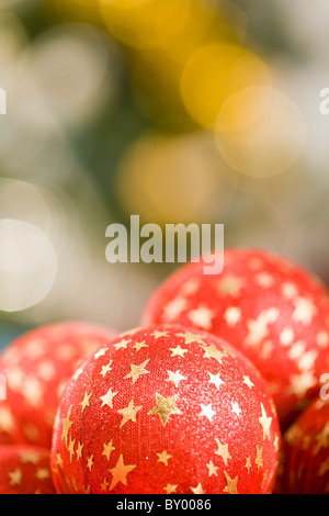 Nahaufnahme von roten dekorative Kugel mit goldenen Sternen auf seiner Oberfläche im Hintergrund von anderen Spielsachen Stockfoto