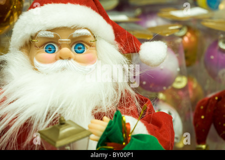 Foto von Spielzeug Weihnachtsmann tragen Brillen und roten Pelzmütze in Einkaufszentrum Stockfoto